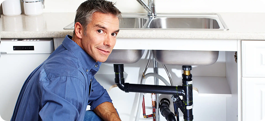 Plumber working under kitchen sink